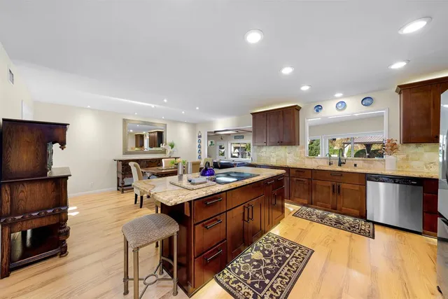 a kitchen with a sink appliances and wooden floor