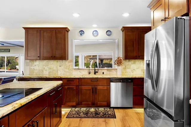 a kitchen with stainless steel appliances granite countertop a sink stove and refrigerator