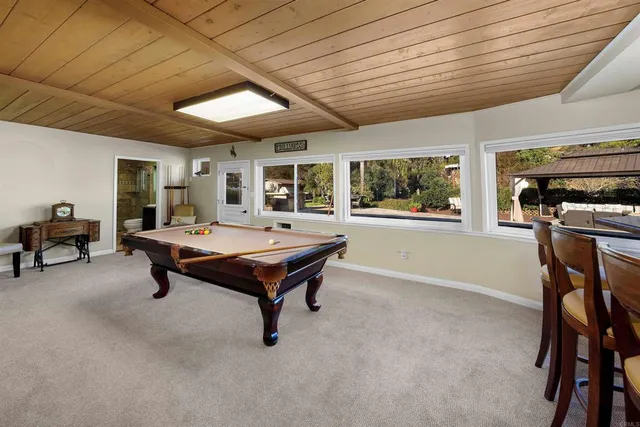 a living room with furniture pool table and a flat screen tv
