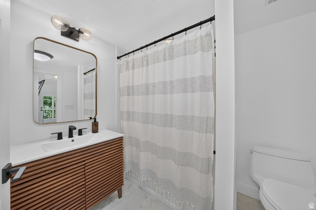 1979 Cave Hollow Way Bountiful, UT 84010 - Photo 36 of 59 Contemporary bathroom featuring a slatted wood-finish vanity, integrated sink, and matte black fixtures
