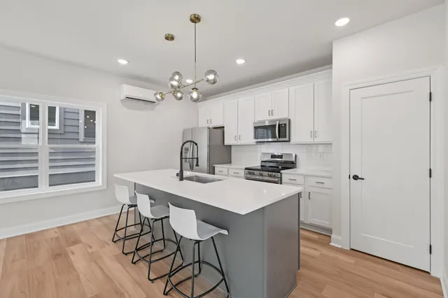a kitchen with kitchen island a stove a table and chairs in it