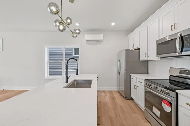 a kitchen with stainless steel appliances a stove refrigerator and microwave