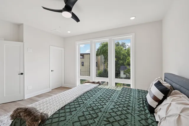 a bedroom with a bed and large windows