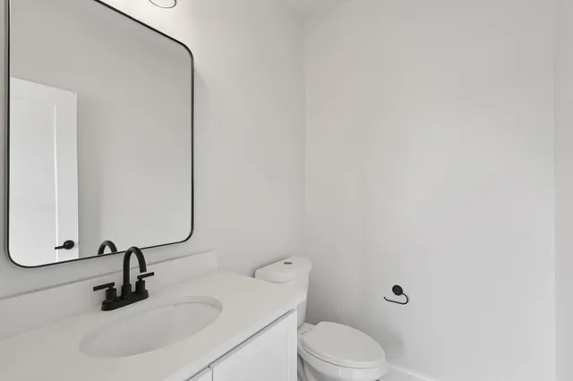 a bathroom with a sink a toilet and a mirror
