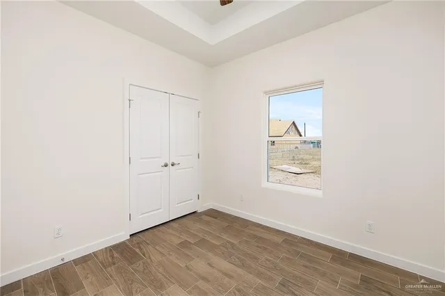 an empty room with wooden floor and window