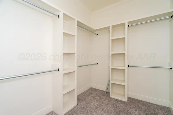 a view of walk in closet with empty racks
