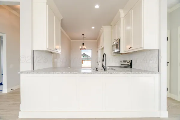 a view of kitchen with kitchen island sink stainless steel appliances and cabinets