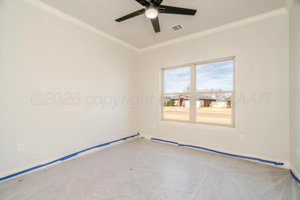 an empty room with a window and a fan