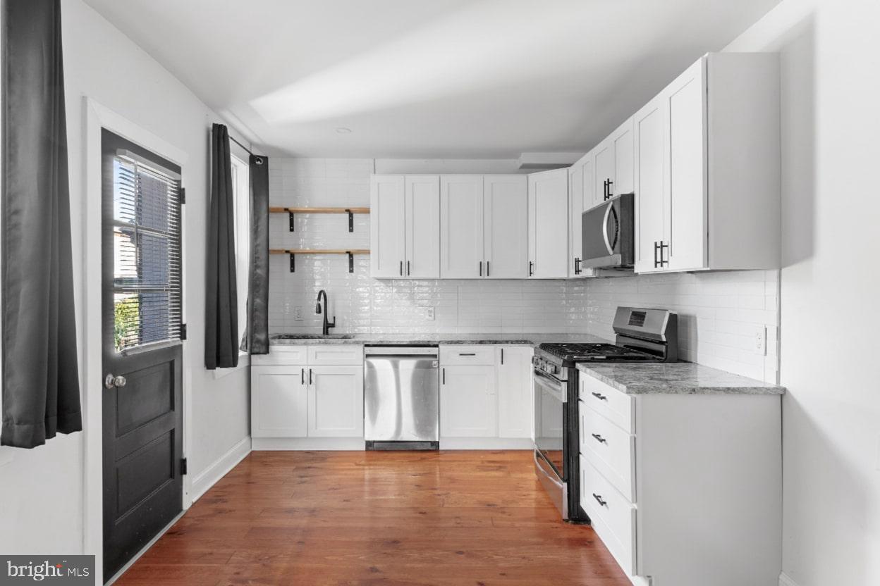 1103 Frances Avenue Lancaster, PA 17601 - Photo 9 of 15 a kitchen with stainless steel appliances granite countertop a stove top oven a refrigerator a sink and white cabinets