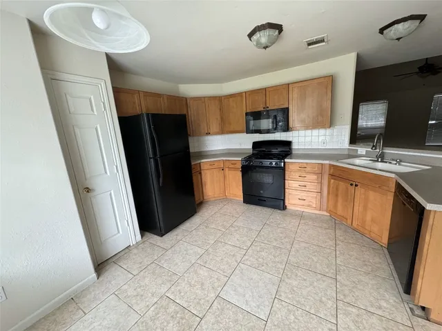 a kitchen with stainless steel appliances granite countertop a refrigerator stove top oven and sink