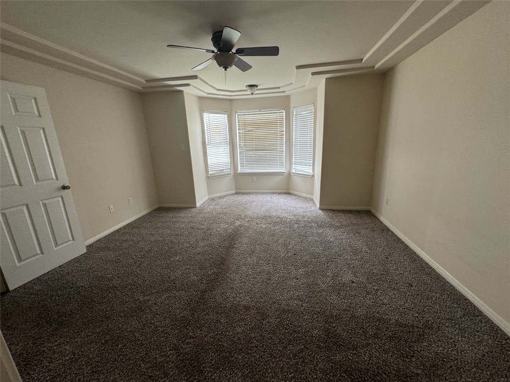 2623 Eastwood Lane Round Rock, TX 78664 - Photo 5 of 12 en empty room with windows and ceiling fan