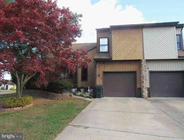 a front view of a house with a garden and trees