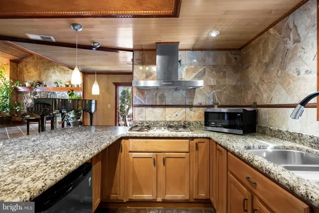 a kitchen with kitchen island a counter top space cabinets and stainless steel appliances