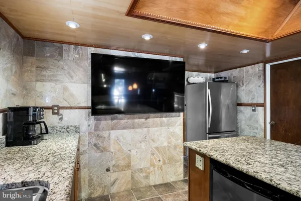 a kitchen with kitchen island a counter top space cabinets and stainless steel appliances