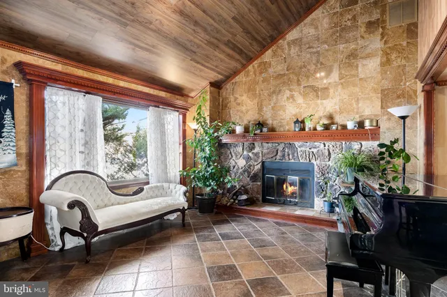 a living room with furniture a fireplace and a dining table with garden view