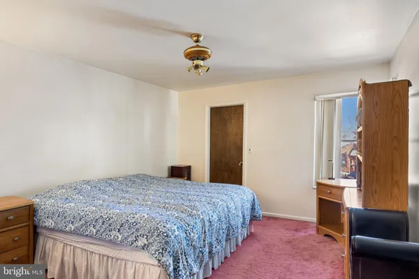 a bedroom with a bed couch and a window