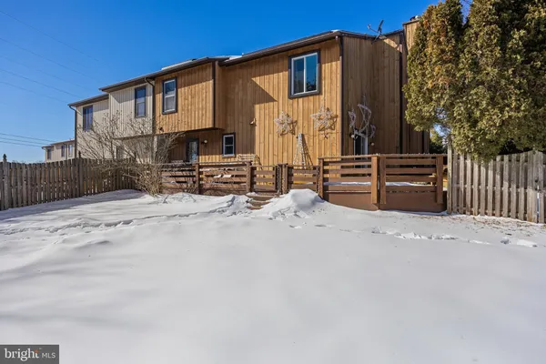 a front view of a house with a snow on the road