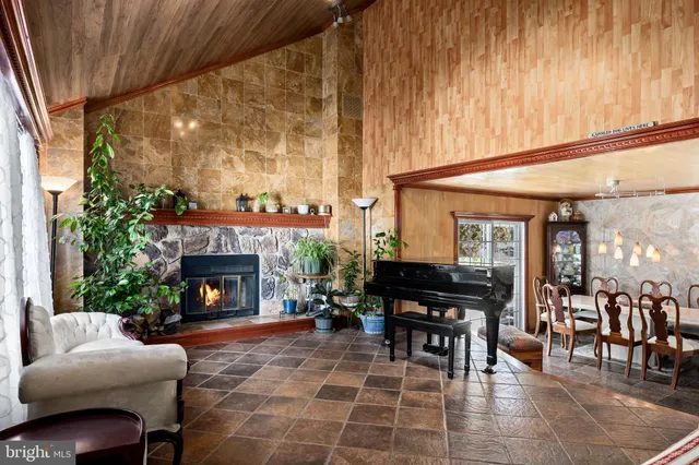 a living room with furniture a piano and a fireplace