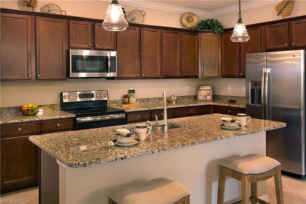 19396 Elston Way Estero, FL 33928 - Photo 3 of 14 a kitchen with stainless steel appliances granite countertop a sink refrigerator and microwave
