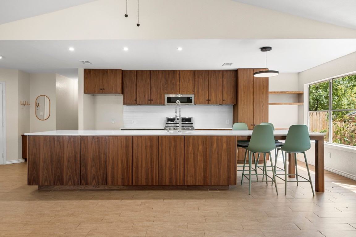 a kitchen with stainless steel appliances a refrigerator and a table