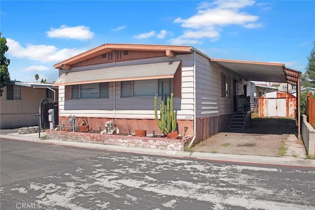 a front view of a house with a large tree