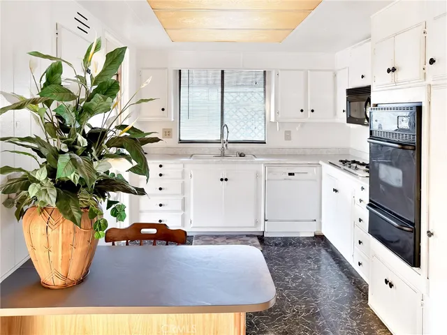 a kitchen with stainless steel appliances kitchen island granite countertop a refrigerator a stove a microwave and cabinets