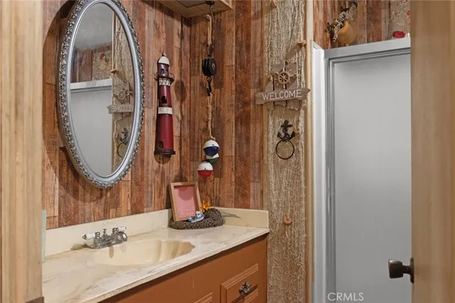 a bathroom with a granite countertop sink a mirror and shower