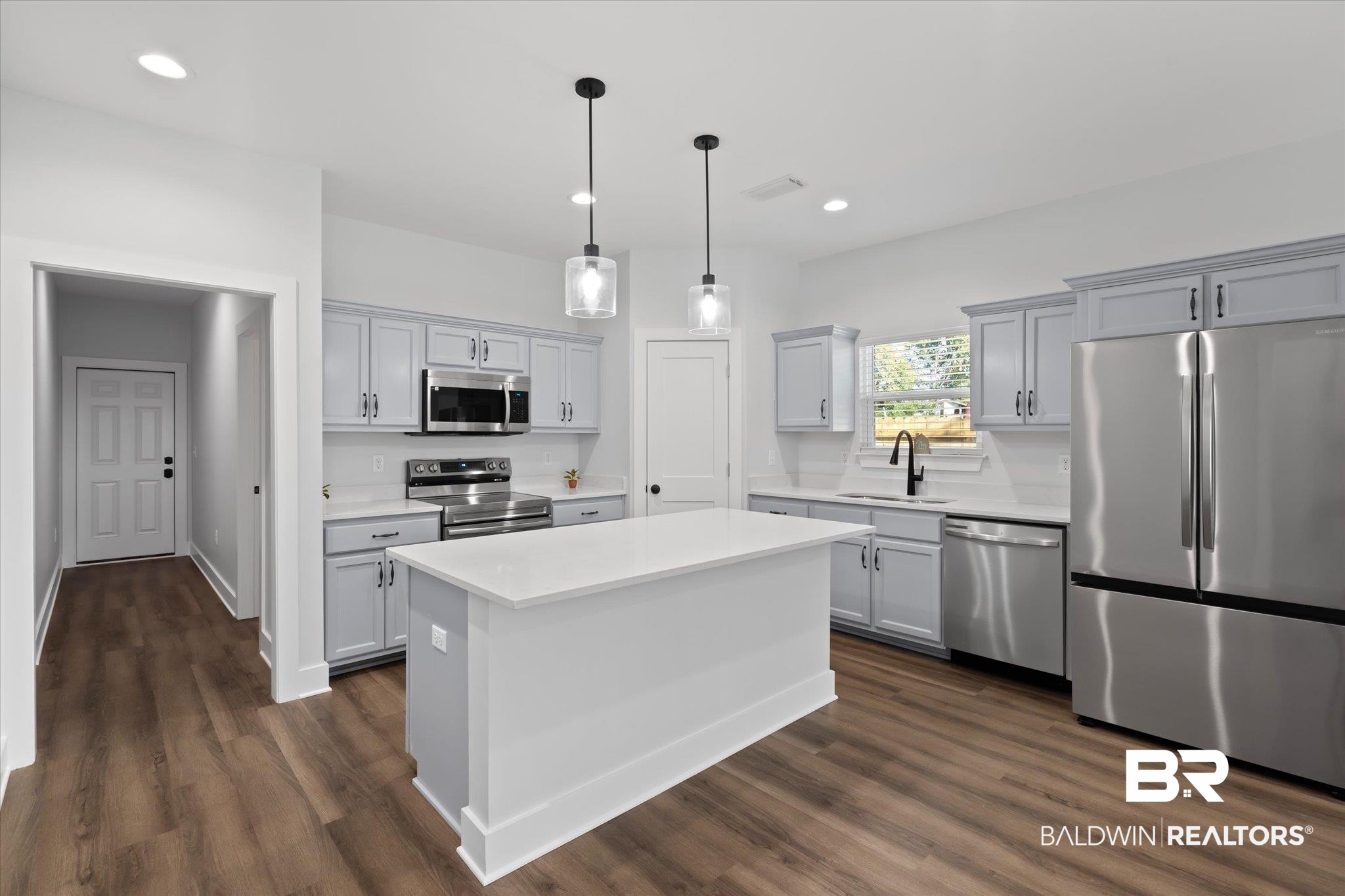 18151 Hoiles Street Robertsdale, AL 36567 - Photo 5 of 23 Kitchen featuring pendant lighting, appliances with stainless steel finishes, a kitchen island, sink, and dark hardwood / wood-style floors