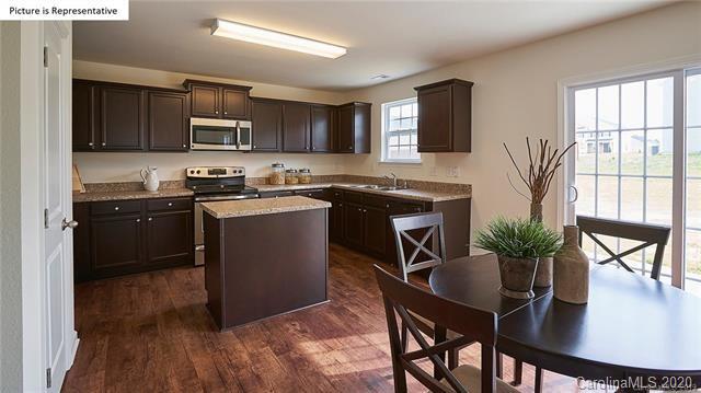 710 Xander Drive, Unit 45 Charlotte, NC 28214 - Photo 14 of 18 a kitchen with a table chairs refrigerator and microwave