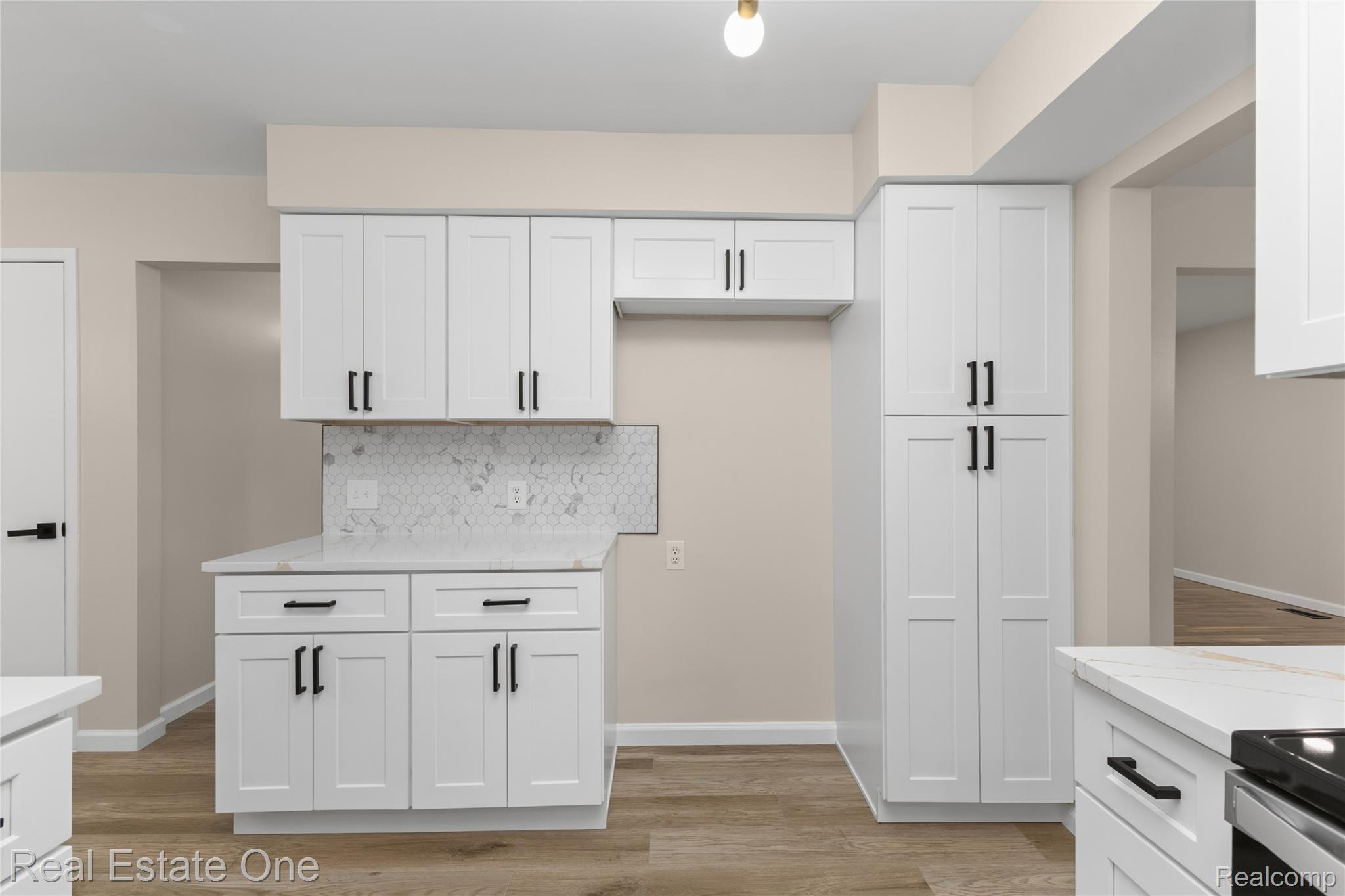 25695 Branchaster Road Farmington, MI 48336 - Photo 15 of 58 White shaker cabinetry with matte black hardware, stone-finish countertops, hexagonal tile backsplash, and wood-finish flooring
