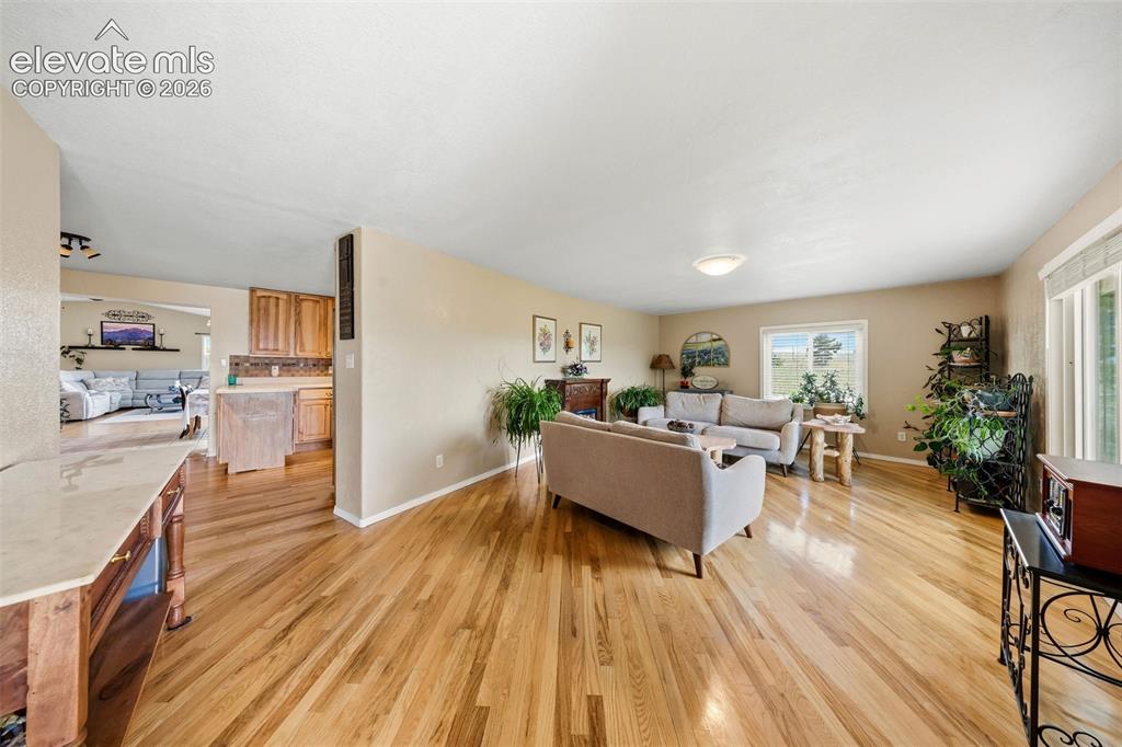 13075 Blaney Road South Peyton, CO 80831 - Photo 4 of 40 Spacious living area featuring light wood-finish flooring and ample natural light from multiple windows