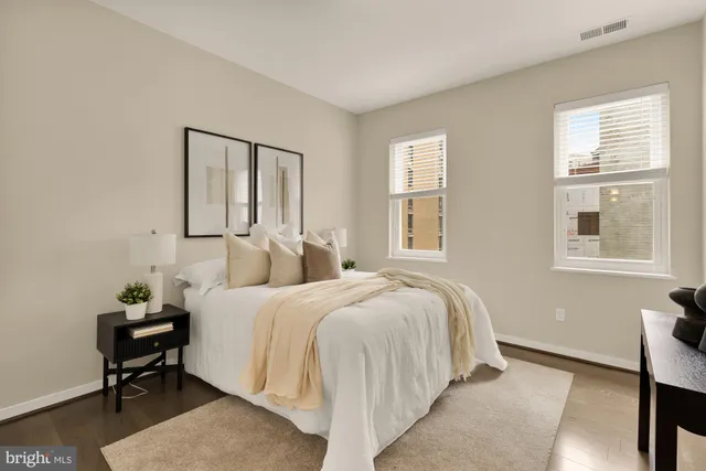 a bedroom with a bed table chair and a window