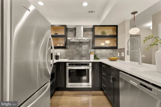 a kitchen with stainless steel appliances granite countertop a refrigerator and a sink