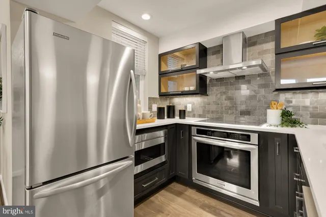 a kitchen with stainless steel appliances a stove microwave and sink
