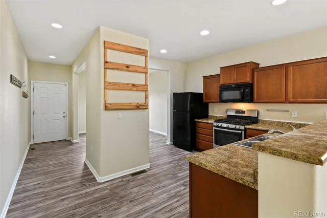 a view of a kitchen with stainless steel appliances wooden floor and a large window