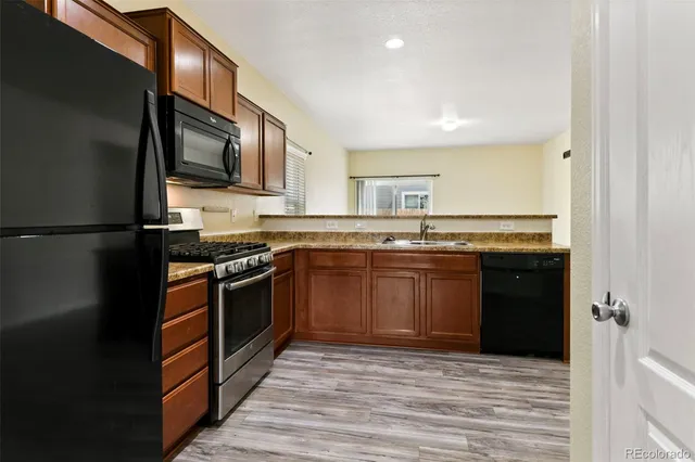 a kitchen with stainless steel appliances granite countertop a stove a sink and a microwave