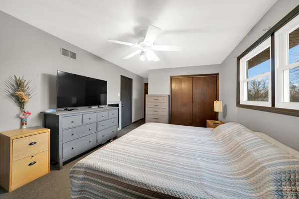 a bedroom with a bed flat screen tv and a window