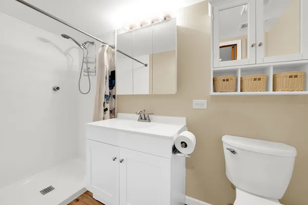 a bathroom with a sink a toilet and shower