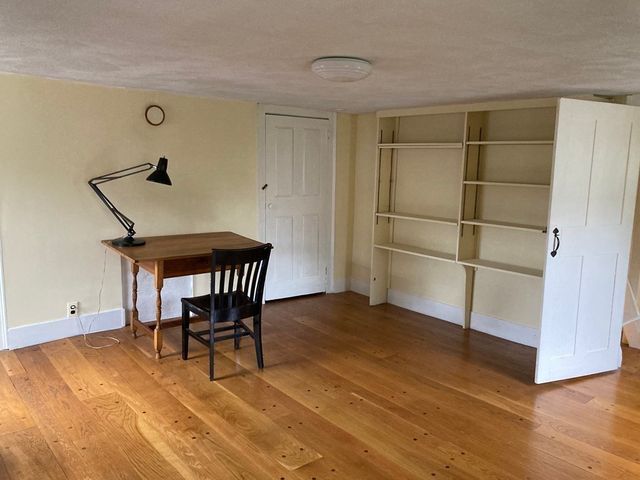 a view of a room with wooden floor and windows