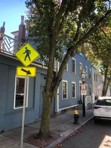 a view of a house with a cars park fire pit and a large tree