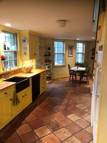 a kitchen with a sink and chairs