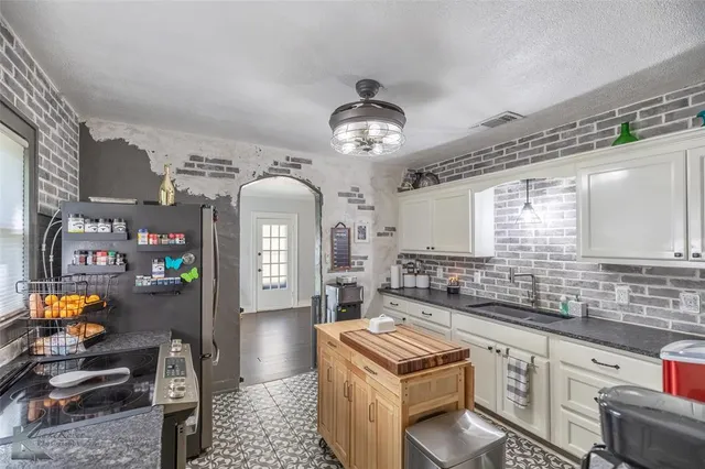 a kitchen with stainless steel appliances granite countertop a stove a sink and a refrigerator