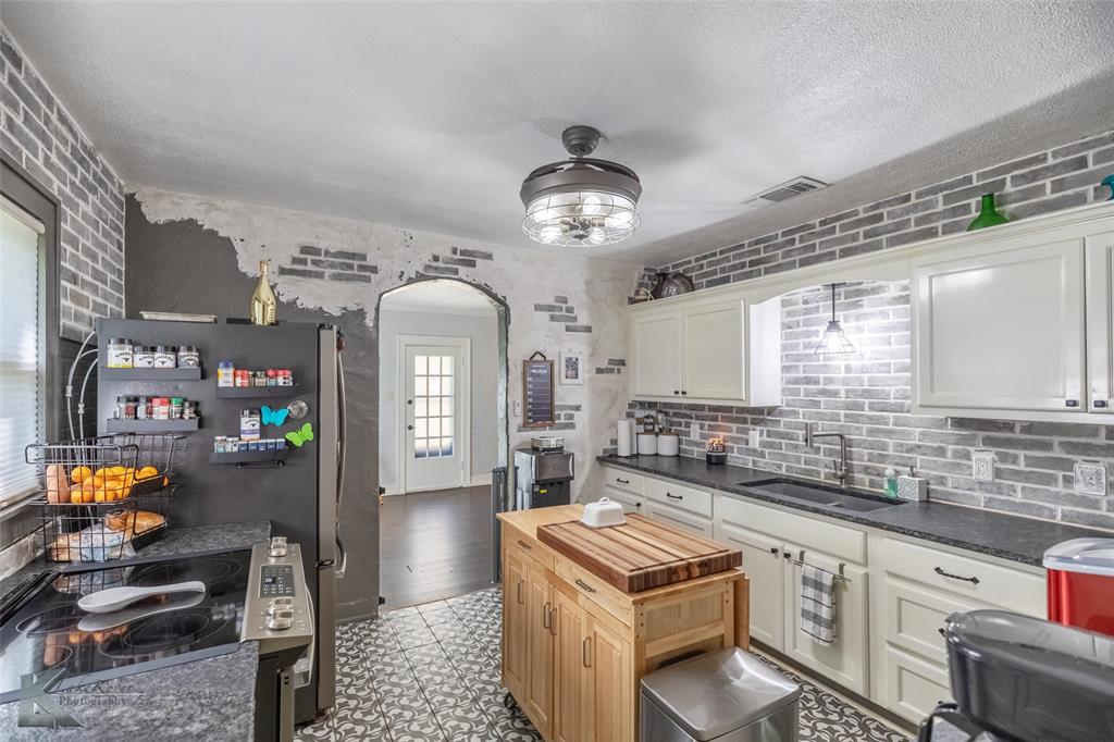 202 East Ross Street Rising Star, TX 76471 - Photo 14 of 40 a kitchen with stainless steel appliances granite countertop a stove a sink and a refrigerator
