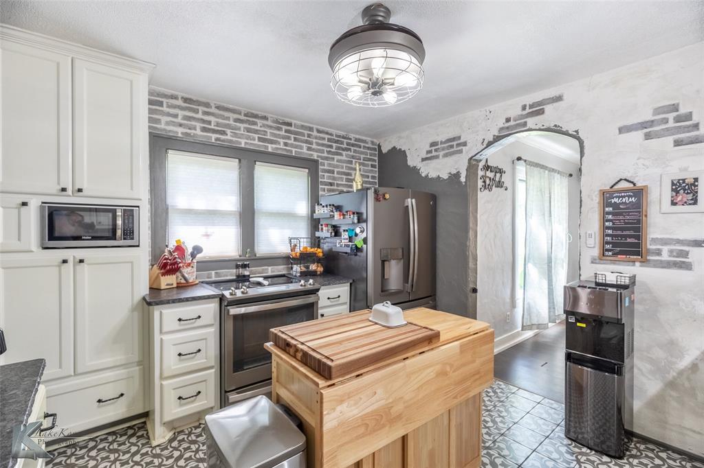 202 East Ross Street Rising Star, TX 76471 - Photo 16 of 40 a kitchen with stainless steel appliances a stove refrigerator and cabinets