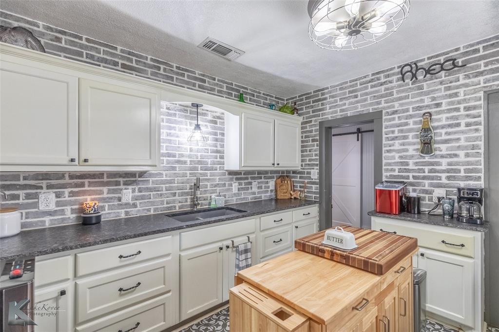 202 East Ross Street Rising Star, TX 76471 - Photo 18 of 40 a kitchen that has a sink and a stove