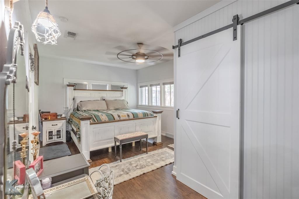 202 East Ross Street Rising Star, TX 76471 - Photo 20 of 40 a bed room with a bed and a chandelier