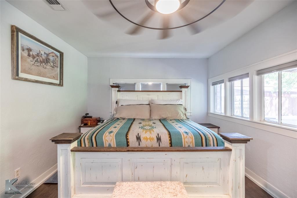 202 East Ross Street Rising Star, TX 76471 - Photo 21 of 40 a view of a bedroom with a bed and wooden floor