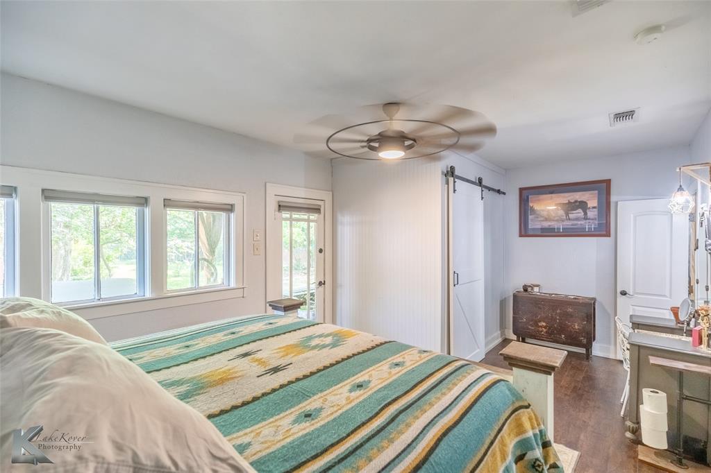 202 East Ross Street Rising Star, TX 76471 - Photo 22 of 40 a bedroom with a bed and a chandelier