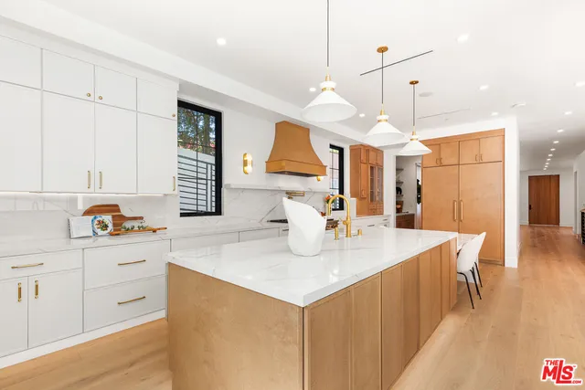 a kitchen with a sink a center island and a wooden floor