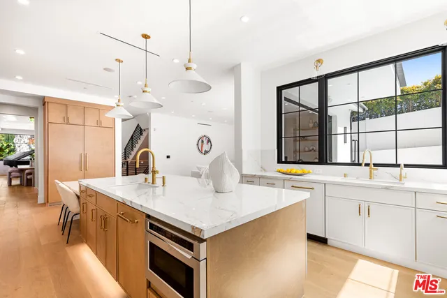 a bathroom with a granite countertop sink and large window